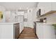 Bright, open kitchen with white cabinetry, stainless steel appliances, and hardwood floors for modern living at 9248 Salida St, Commerce City, CO 80022