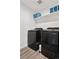 Modern laundry room features gray wood-look floors, sleek Samsung washer and dryer, and a shelf for storage at 9248 Salida St, Commerce City, CO 80022