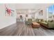 Open-concept living room with high ceilings, hardwood floors, a modern sofa and view of the kitchen at 9248 Salida St, Commerce City, CO 80022