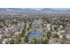 Picturesque aerial view of a neighborhood with ponds, mature trees, and beautiful mountain views in the distance at 4323 W Ponds Cir, Littleton, CO 80123