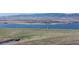 Expansive aerial view of a dam and reservoir surrounded by rolling green hills and distant mountains at 4323 W Ponds Cir, Littleton, CO 80123