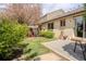 Private backyard featuring a patio, lush lawn, and vibrant flowering tree at 4323 W Ponds Cir, Littleton, CO 80123