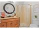 Updated bathroom showcasing a granite vanity, round mirror, and glass shower at 4323 W Ponds Cir, Littleton, CO 80123