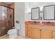 Bathroom featuring double vanity, orange tile accents, and a glass door shower at 4323 W Ponds Cir, Littleton, CO 80123