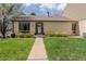 Charming brick home featuring a well-manicured lawn and inviting front entryway with a wreath on the front door at 4323 W Ponds Cir, Littleton, CO 80123