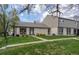 Inviting home featuring well-kept lawn, brick facade, and welcoming front entrance, complemented by mature trees at 4323 W Ponds Cir, Littleton, CO 80123