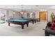 Spacious game room with two billiard tables and classic lighting fixtures at 4323 W Ponds Cir, Littleton, CO 80123