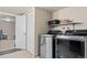 Well-organized laundry room with front-loading machines and ample shelving for storage at 4323 W Ponds Cir, Littleton, CO 80123