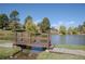 Picturesque pond with a wooden bridge, surrounded by lush greenery and mature trees at 4323 W Ponds Cir, Littleton, CO 80123