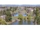 Scenic view of a tranquil pond with lush greenery and mature trees reflecting on the water's surface at 4323 W Ponds Cir, Littleton, CO 80123