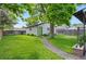 Spacious backyard with lush green grass, a charming garden, and a quaint pathway leading to the house at 3052 S Logan St, Englewood, CO 80113