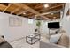 Finished basement with exposed wooden ceiling, neutral decor and ample seating at 3052 S Logan St, Englewood, CO 80113