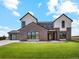 Stunning two-story home featuring mixed brick and siding with a sleek black metal roof and black window trim at 5145 S Kearney Ct, Greenwood Village, CO 80111