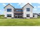 Modern farmhouse with a black metal roof and matching black trimmed windows overlooking a large green lawn at 5145 S Kearney Ct, Greenwood Village, CO 80111