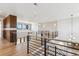 Upstairs hallway with wooden floors and dark metal railing offers bright, open space at 5145 S Kearney Ct, Greenwood Village, CO 80111