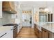 Modern kitchen featuring white cabinets, stainless steel appliances, and a gray tile backsplash at 5145 S Kearney Ct, Greenwood Village, CO 80111