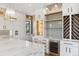 Bright kitchen featuring white cabinetry, an island with a marble countertop, and a wine rack at 5145 S Kearney Ct, Greenwood Village, CO 80111