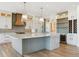 Bright kitchen with a large island, built-in wine cooler, and modern lighting fixtures at 5145 S Kearney Ct, Greenwood Village, CO 80111