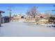 Snowy backyard with storage shed and chain link fence at 5621 Demott Ave, Commerce City, CO 80022