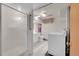 View of a clean basement bathroom with shower and laundry area at 5621 Demott Ave, Commerce City, CO 80022