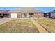 Brick ranch house with attached garage and landscaped yard at 5621 Demott Ave, Commerce City, CO 80022