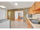Kitchen boasts wood cabinets and a stone accent wall at 5621 Demott Ave, Commerce City, CO 80022