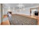Large living room with hardwood floors, fireplace, and access to kitchen at 5621 Demott Ave, Commerce City, CO 80022