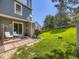 Inviting backyard features a well-maintained lawn, patio area, and mature trees providing shade at 9736 W Cornell Pl, Lakewood, CO 80227