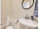 Tastefully designed half bathroom with pedestal sink and modern fixtures at 9736 W Cornell Pl, Lakewood, CO 80227