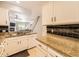 Well-lit kitchen featuring granite counters, white cabinets and stainless steel appliances at 9736 W Cornell Pl, Lakewood, CO 80227