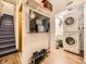 Functional laundry area with washer, dryer, television, and shelving for organized storage at 9736 W Cornell Pl, Lakewood, CO 80227