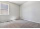 Bright, empty bedroom featuring neutral walls, a window with neighborhood views, and soft gray carpeting at 25023 N 34Th Ave, Aurora, CO 80019