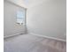 Bright, empty bedroom featuring neutral walls, a window with neighborhood views, and soft gray carpeting at 25023 N 34Th Ave, Aurora, CO 80019