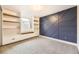 This flex room features built-in bookshelves and an accent wall with geometric shapes at 2540 Kendall St, Edgewater, CO 80214