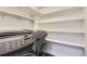 Convenient laundry area with front load washer and ample shelving for storage at 2540 Kendall St, Edgewater, CO 80214