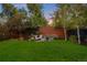 Private backyard featuring a lush green lawn, brick wall, wooden fence, and a cozy outdoor lounge area at 2383 Jasmine St, Denver, CO 80207