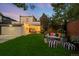 Private fenced backyard with a lush lawn, patio seating, and garage with driveway at 2383 Jasmine St, Denver, CO 80207