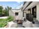 Cozy backyard patio featuring an outdoor fireplace, stylish seating, and charming string lights at 2383 Jasmine St, Denver, CO 80207