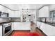 Modern kitchen boasts white cabinets, stainless steel appliances, dark countertops, and hardwood floors at 2383 Jasmine St, Denver, CO 80207