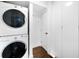 Well-equipped laundry area featuring a stacked washer and dryer, maximizing space and functionality at 2383 Jasmine St, Denver, CO 80207