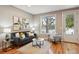 Bright living room featuring a comfortable sofa, stylish decor, and a large window at 3482 E 28Th Ave, Denver, CO 80205