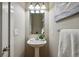 Clean and well-lit powder room with a pedestal sink and decorative lighting at 3482 E 28Th Ave, Denver, CO 80205