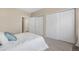 Inviting bedroom featuring carpet, closet with sliding doors, and neutral walls at 8406 Pebble Creek Way # 202, Highlands Ranch, CO 80126
