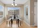 Bright dining area features a modern glass table, stylish chairs, and natural light from large windows at 8406 Pebble Creek Way # 202, Highlands Ranch, CO 80126