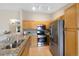 Well-lit kitchen features stainless steel appliances, granite countertops, and warm-toned wooden cabinetry and fixtures at 8406 Pebble Creek Way # 202, Highlands Ranch, CO 80126