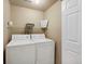 Bright laundry area equipped with a white washer, a white dryer, and overhead shelf at 8406 Pebble Creek Way # 202, Highlands Ranch, CO 80126