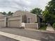 Charming beige townhouse with a two-car garage and inviting outdoor patio area at 5898 W Asbury Pl, Lakewood, CO 80227