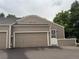 Beige home featuring a two-car garage and a charming entrance with a security door at 5898 W Asbury Pl, Lakewood, CO 80227