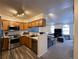 Modern kitchen with stainless steel appliances and wooden cabinets, open to the living area at 5898 W Asbury Pl, Lakewood, CO 80227
