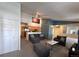 Inviting living room with grey furniture, textured carpet, and view into kitchen area at 5898 W Asbury Pl, Lakewood, CO 80227